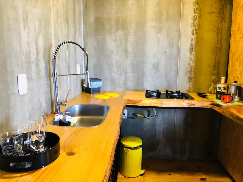a kitchen with a sink and a wooden counter top at Cabana Fortaleza - Pousada Colina dos Ventos in Urubici