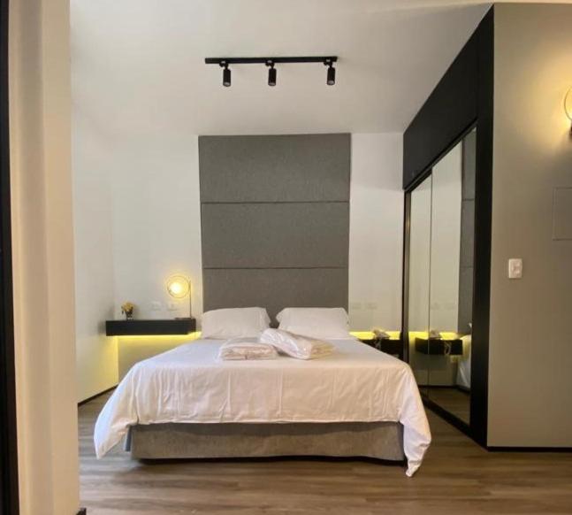 a bedroom with a large bed with a large mirror at JP CRAUFORD HOSPEDAGEM LORENA in Sao Paulo