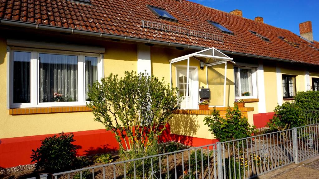 ein gelbes und rotes Haus mit Fenstern und Pflanzen in der Unterkunft Auszeit Sembzin in Klink