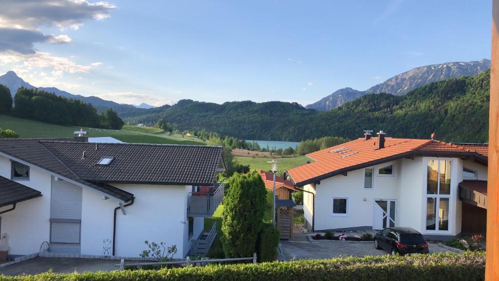 einen Blick auf zwei Häuser mit Bergen im Hintergrund in der Unterkunft Ferienwohnung Mayr in Füssen