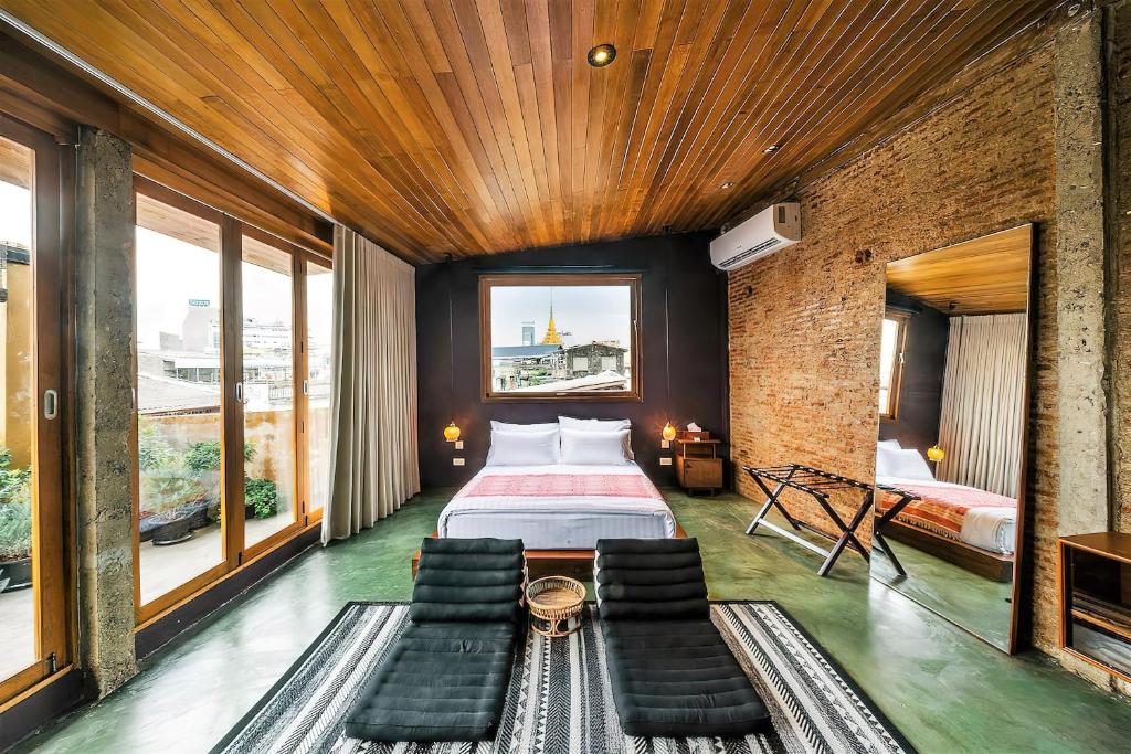 a bedroom with a bed in a room with windows at Ba Hao Residence in Bangkok