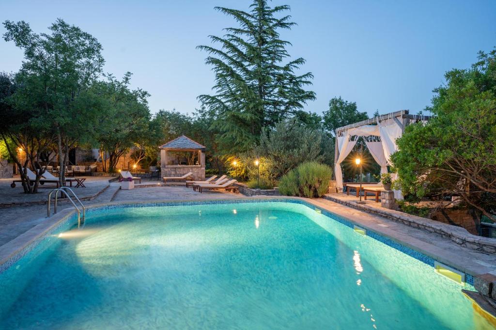 a swimming pool in a backyard with a gazebo at Nono Ban Hotel & Villa in Gornji Humac