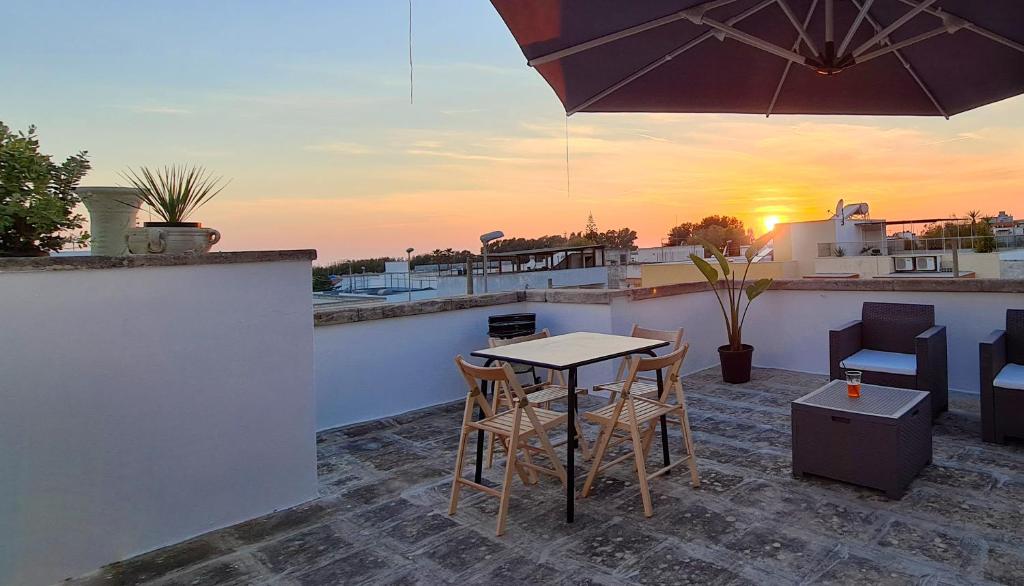 a patio with a table and chairs and an umbrella at GAYA MARINA in Lido Marini