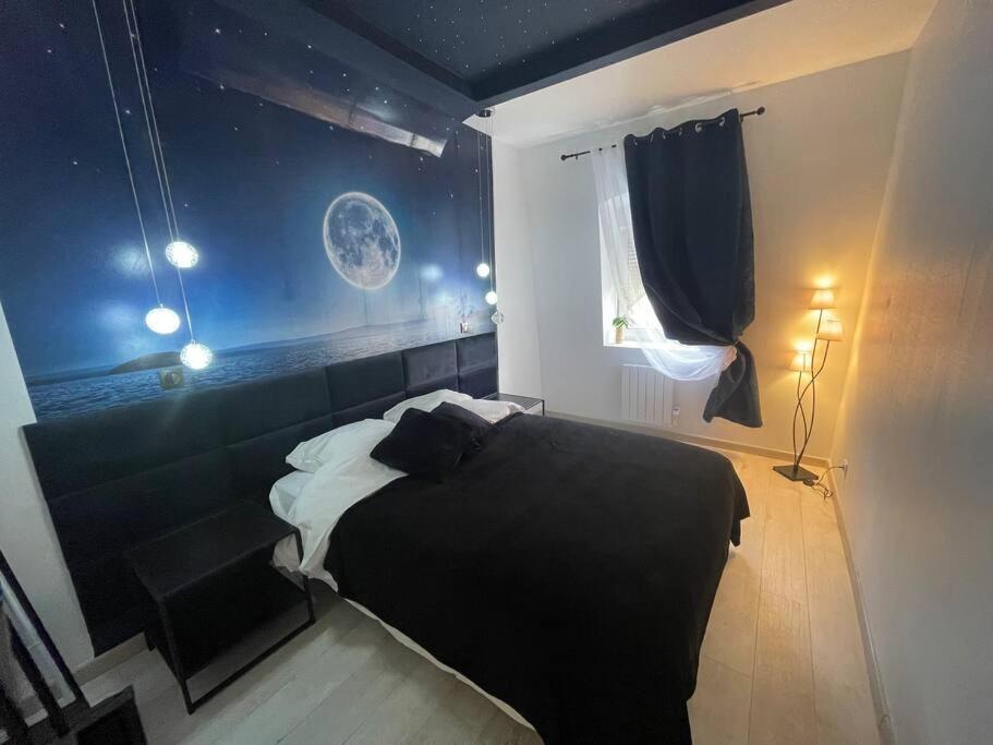 a bedroom with a black and white bed and a window at Esprit BALI ....LOVE SPA, Sauna de luxe à Mulhouse in Mulhouse
