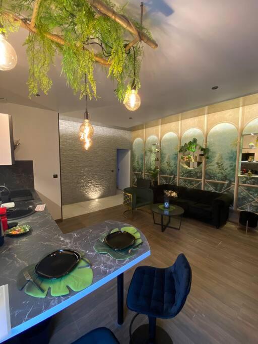 salon ze stołem, krzesłami i kanapą w obiekcie Esprit BALI ....LOVE SPA, Sauna de luxe à Mulhouse w Miluzie