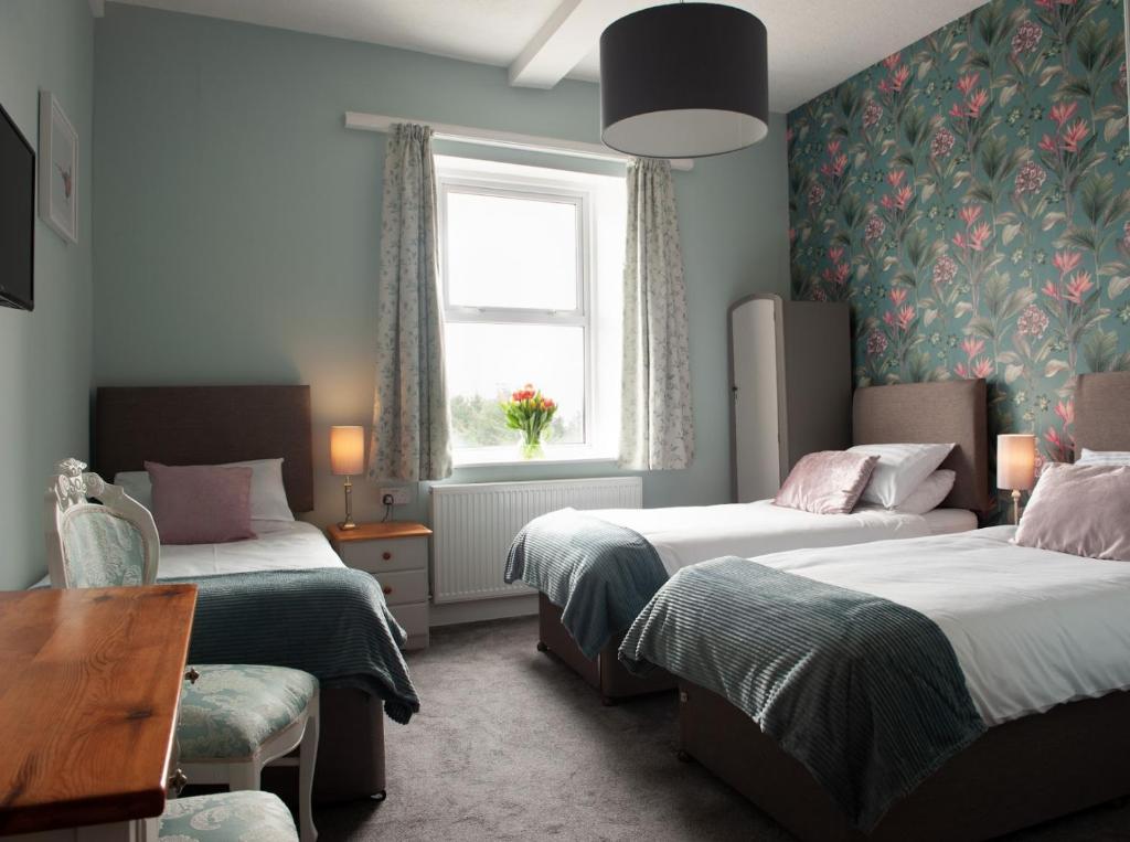 Habitación de hotel con 2 camas y ventana en Duchy House Bed and Breakfast, en Princetown