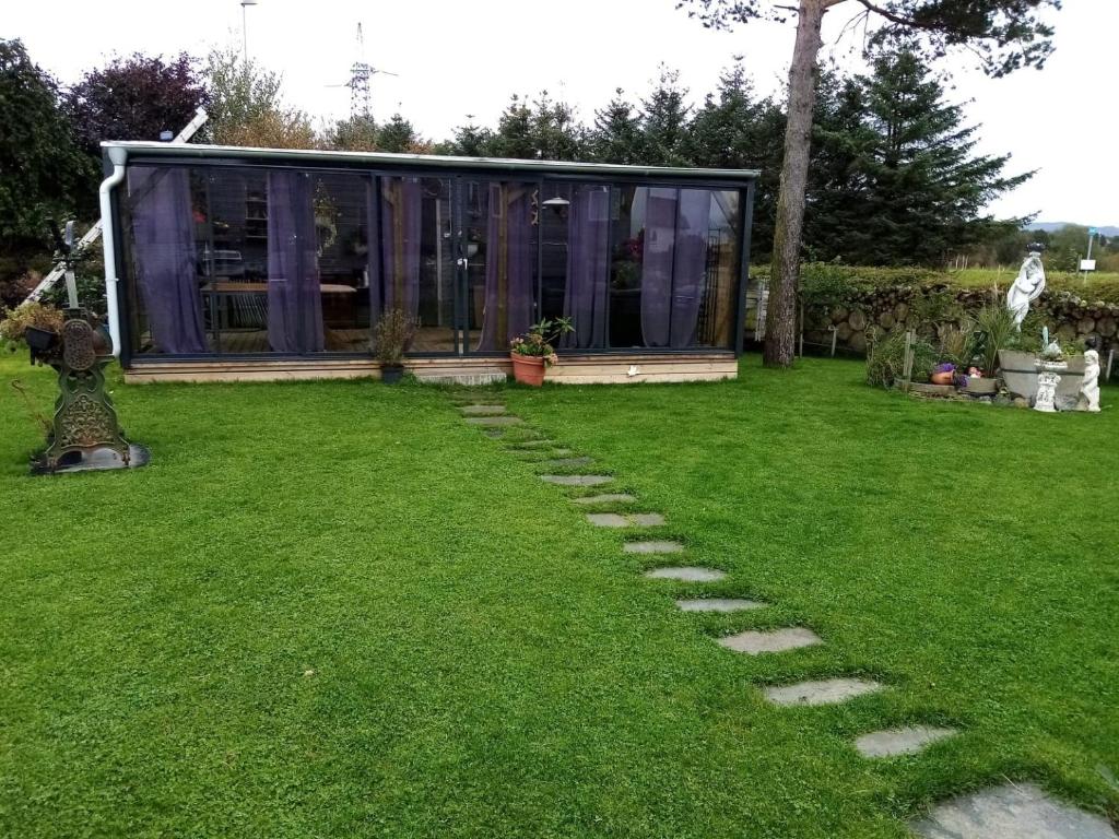 a garden with a glass house on the grass at Garden Guest House Room with Terrace in Stavanger
