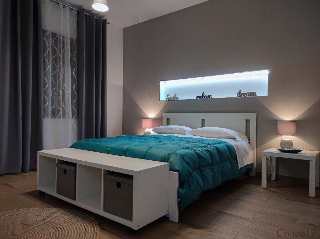 um quarto com uma cama com um cobertor azul em Civico17 em Santa Ninfa