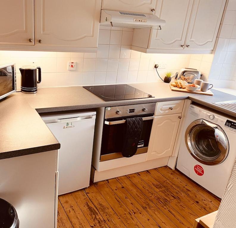 a kitchen with white cabinets and a dishwasher at The Ramblers Rest - whole apartment - pet friendly - close to amenities and walks in Edzell