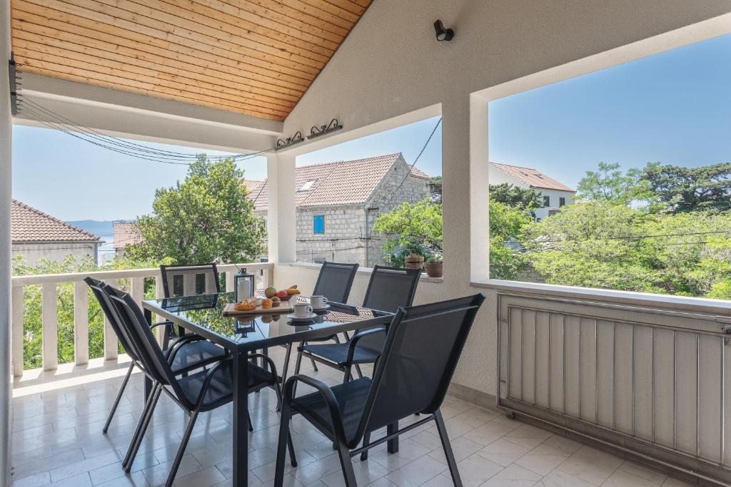 a dining room with a table and chairs on a balcony at Center apartment Golden Ray in Bol