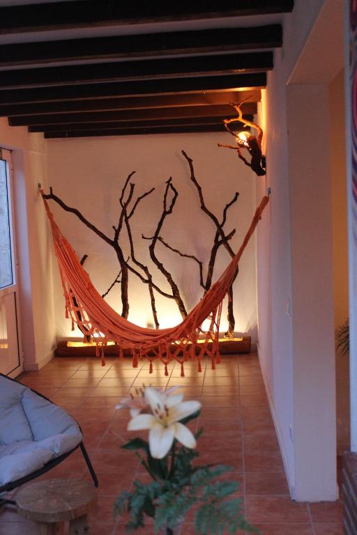 a hammock in a living room with a tree at 5th Element Beach House Caparica in Costa da Caparica