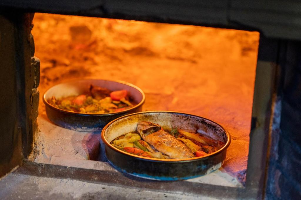 two bowls of food in an oven with food at Nono Ban Hotel & Villa in Gornji Humac