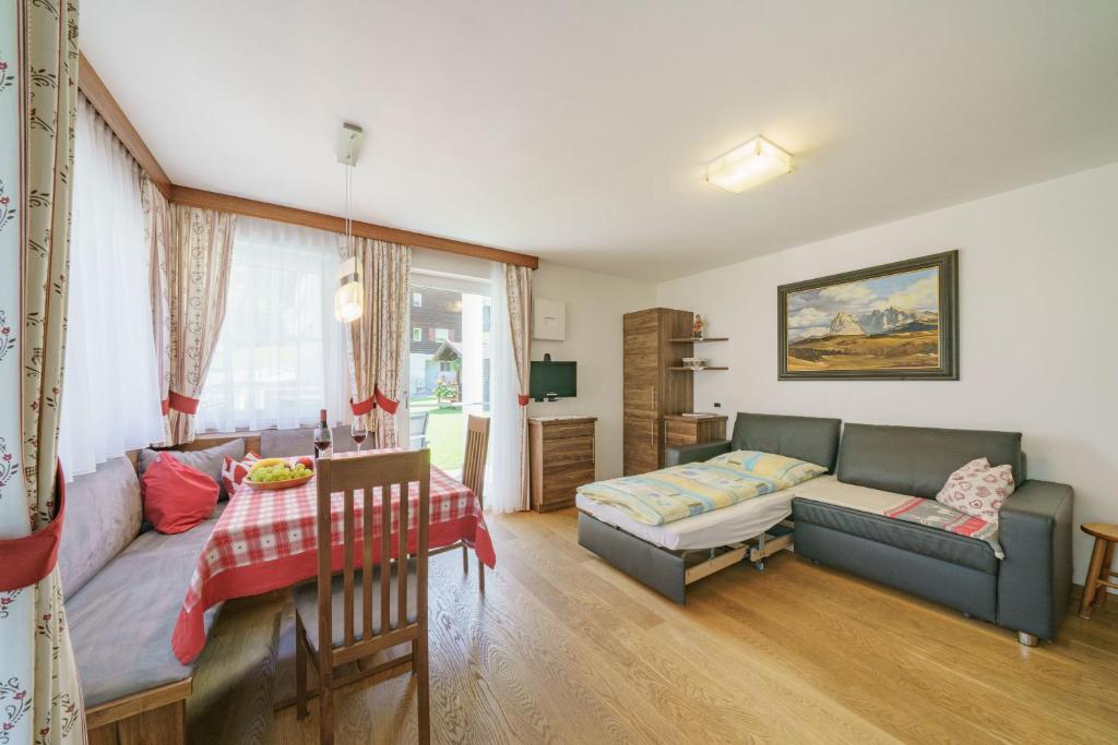 - un salon avec un canapé et une table dans l'établissement Apartment Romana, à Selva di Val Gardena
