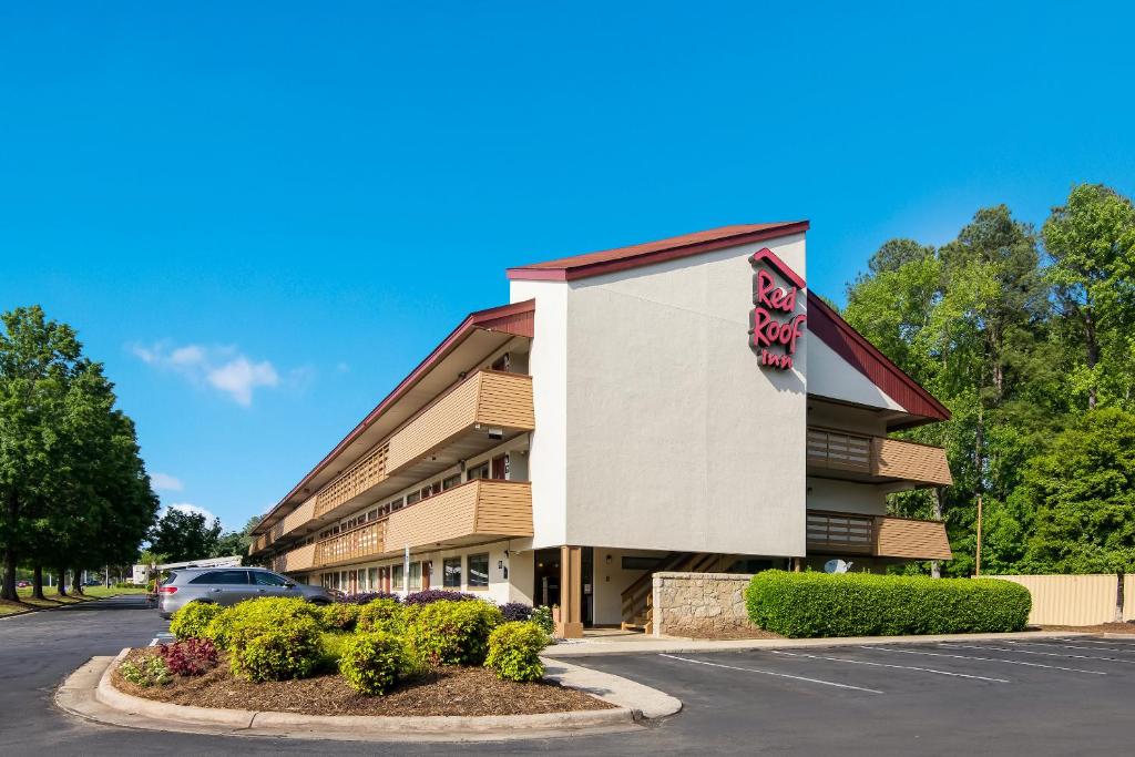 um edifício com um carro estacionado em frente em Red Roof Inn Durham - Triangle Park em Durham