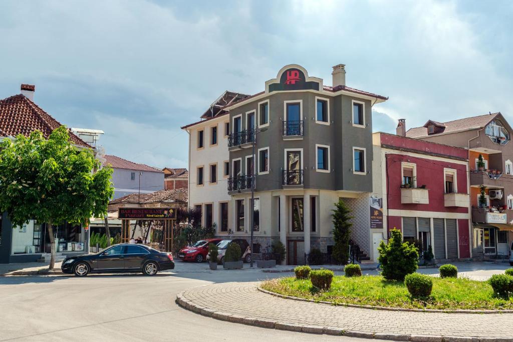 um carro estacionado em frente a um edifício numa rua em Hotel Pazari & Apartments em Korçë
