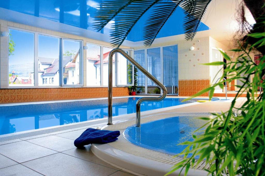 a large swimming pool with a hot tub in a building at Hotel Narcyz in Świeradów-Zdrój