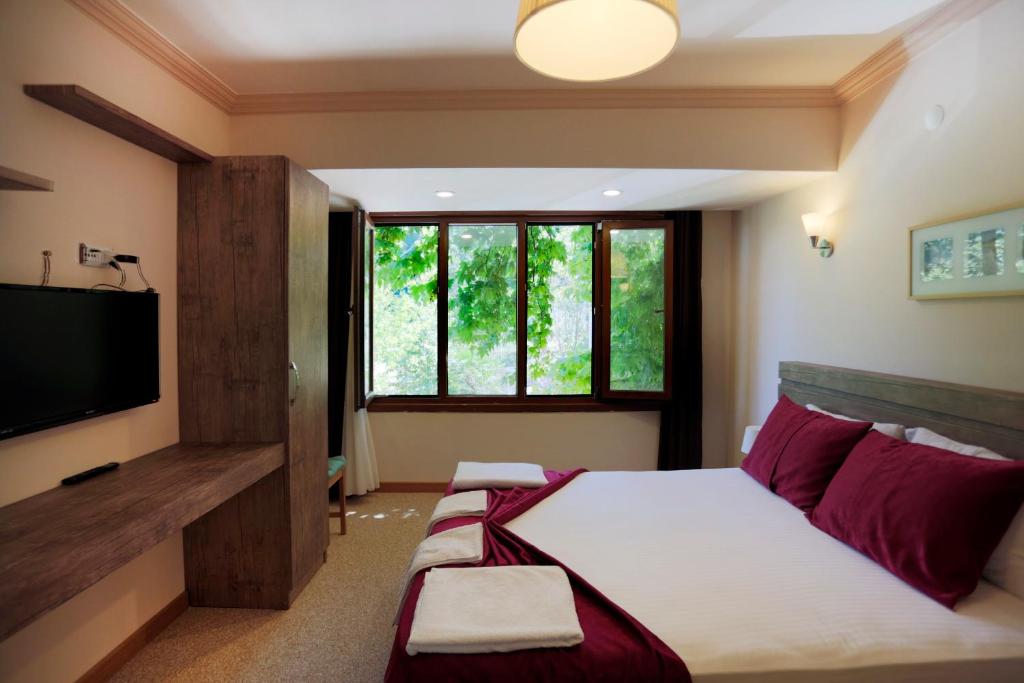 a bedroom with a bed and a flat screen tv at Kapri Termal Hotel & Kaplica Yalova in Termal