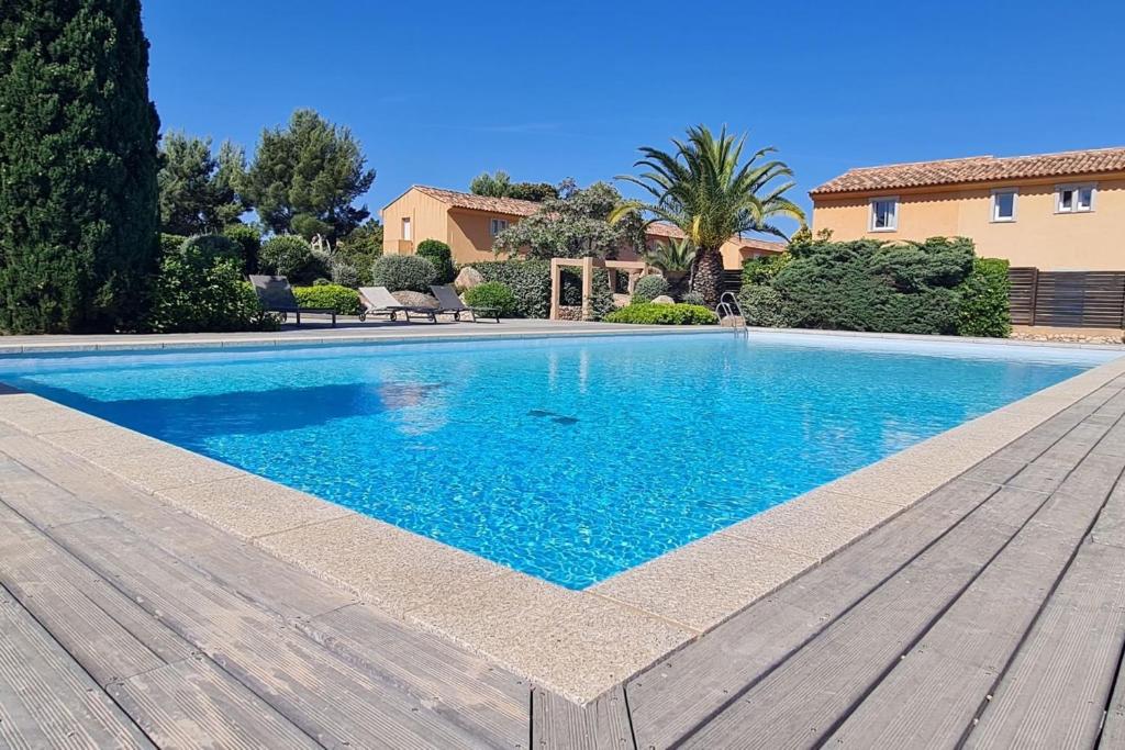 - une piscine dans une cour avec une terrasse en bois dans l'établissement Mini villa Messicana 5 pers piscine 500 m plage, à Lecci