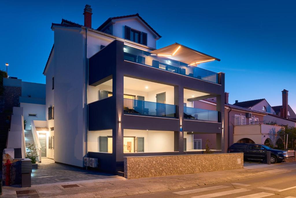 a large white building with balconies at night at House Torre in Mali Lošinj
