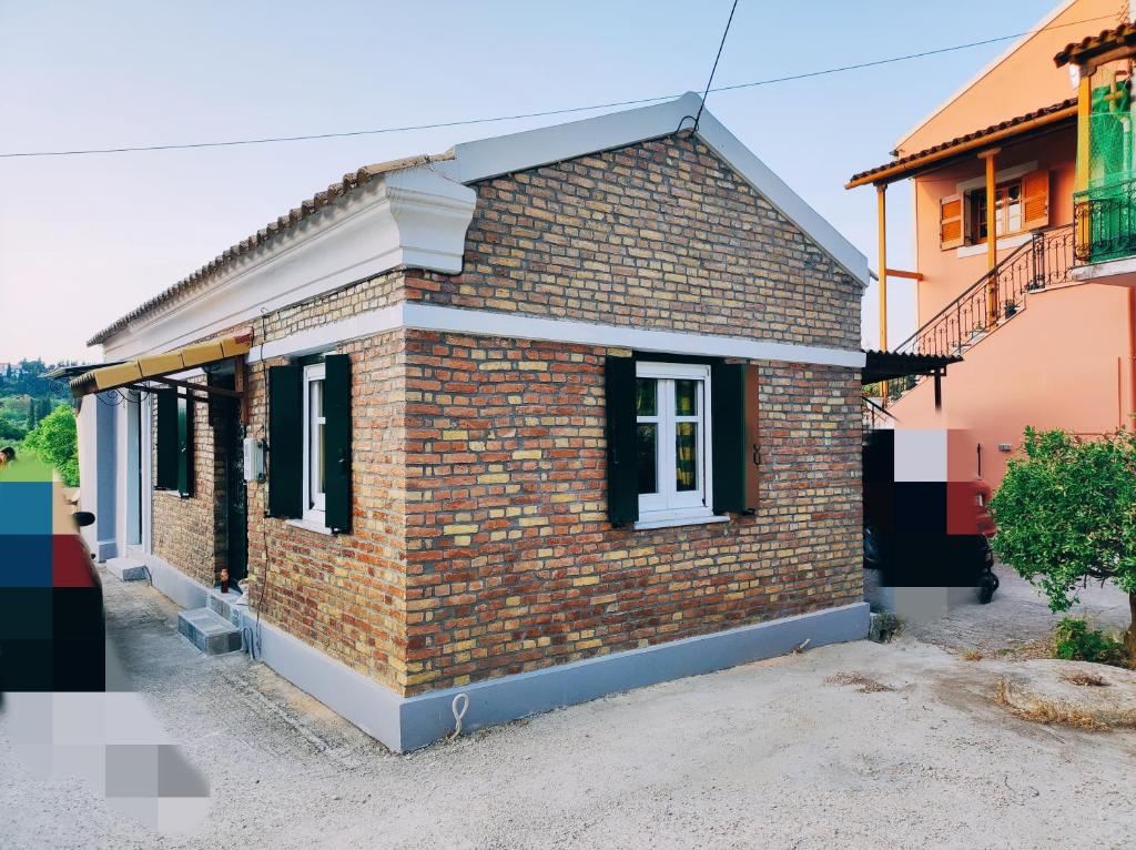a brick house with black windows on a street at Relax like the Old Days in Kastanéa