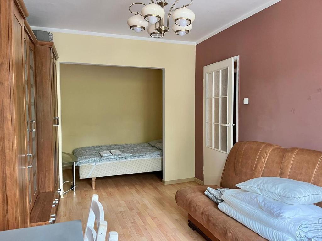uma sala de estar com um sofá e uma cama em Slomiana Apartment em Cracóvia