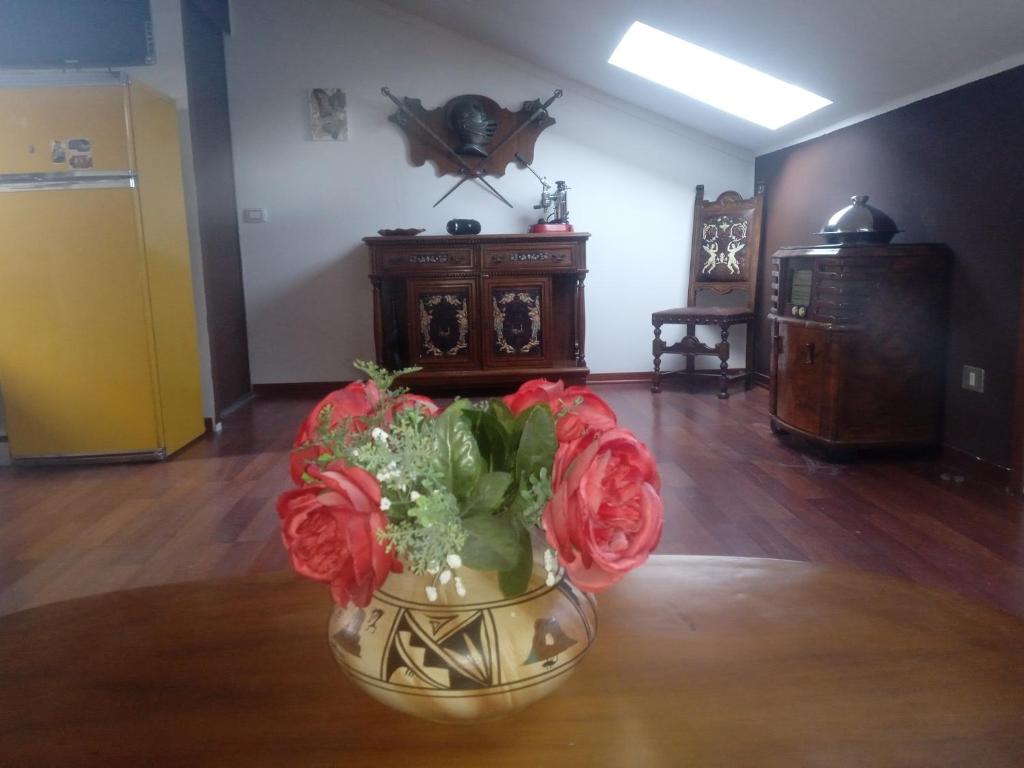 un jarrón lleno de flores sentado en una mesa en " Le Chic", en Pregnana Milanese