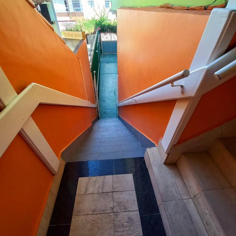 a view of a stairway with orange and blue walls at pousada peracanga in Guarapari