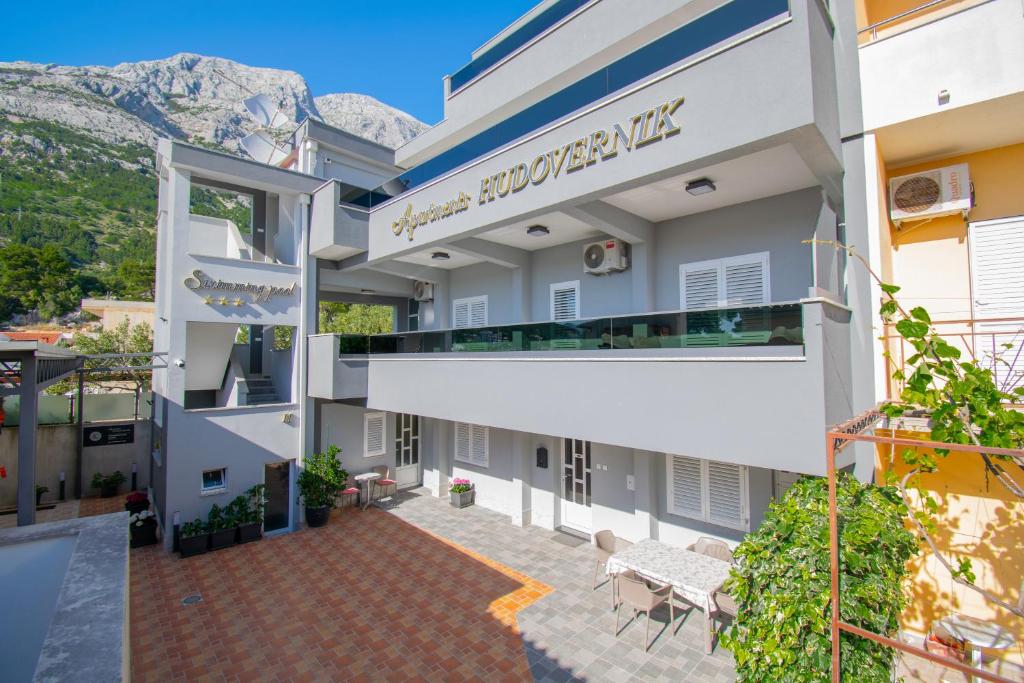 a view of the courtyard of a building with mountains in the background at Apartments Hudovernik in Baška Voda