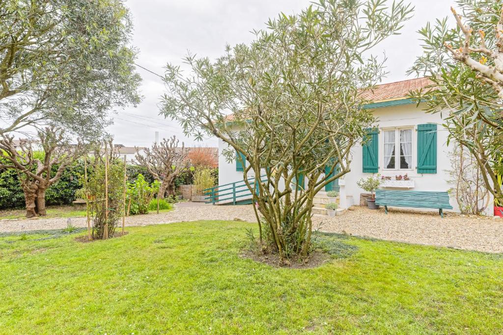 une maison avec un banc vert dans une cour dans l'établissement Toki Eder Anglet - Terrasse - Jardin - Océan -  4 chambres, à Anglet
