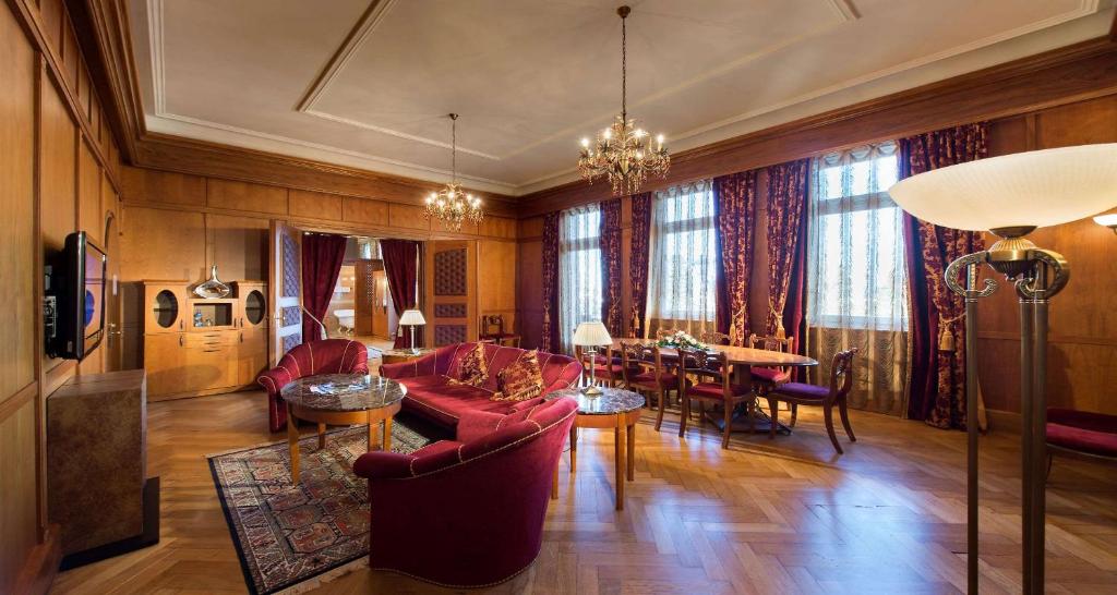 フロイデンシュタットにあるDas Palmenwald Schwarzwaldhof, BW Signature Collectionの赤い家具付きのリビングルーム、ダイニングルーム