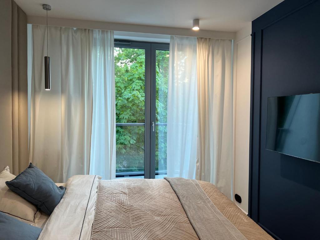 ソポトにあるApollo Luxury Apartment Dolny Sopotのベッドと大きな窓のある寝室