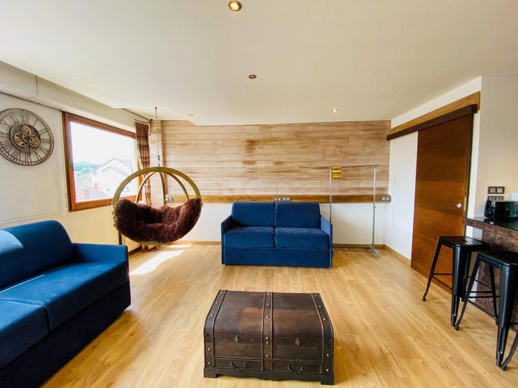 salon z 2 niebieskimi kanapami i stołem w obiekcie La Venise Annécienne - Studio lumineux, avec parking privé gratuit, proche gare w Annecy