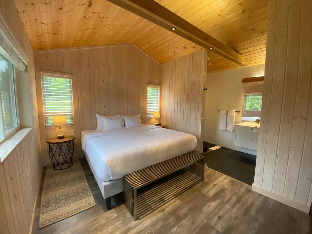 ein Schlafzimmer mit einem weißen Bett in einem Holzzimmer in der Unterkunft Cedar Park Resort in Port McNeill