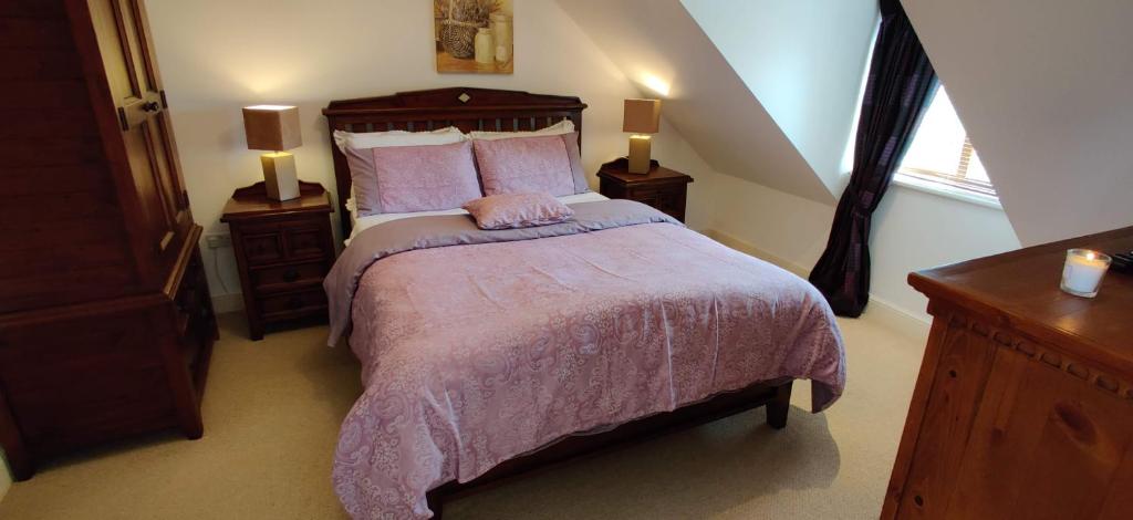 a bedroom with a bed with a purple comforter and a window at 'Neasa' Luxury Double Bedroom in Foxford