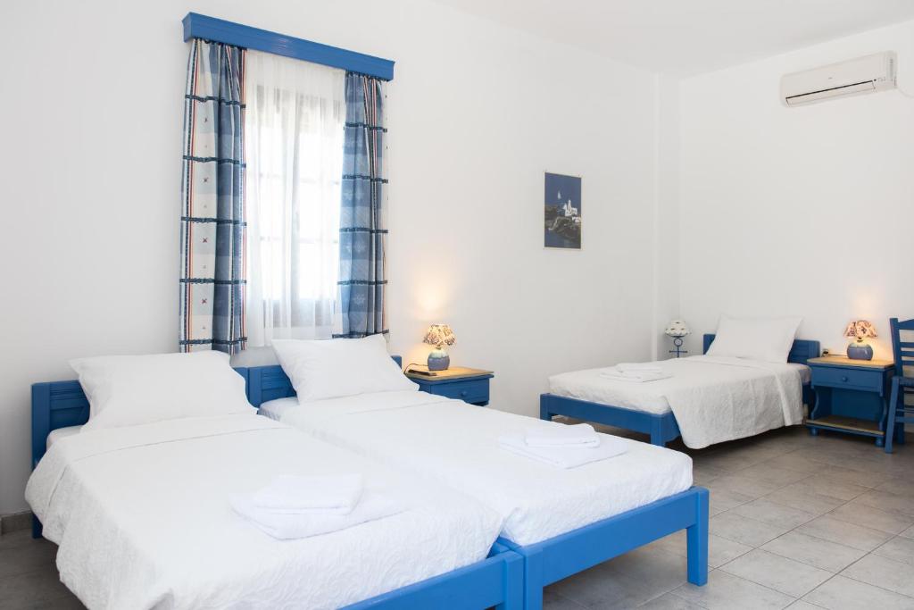 2 camas en una habitación de color azul y blanco en Pigi Rooms, en Apollonia