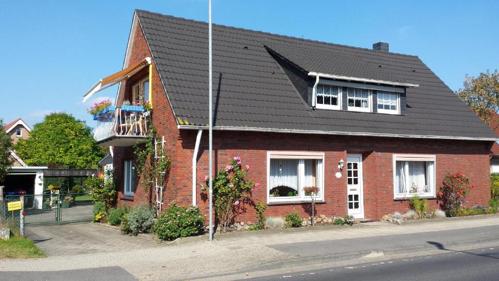 una casa de ladrillo rojo con techo negro en Ferienwohnung Prinz, en Lathen