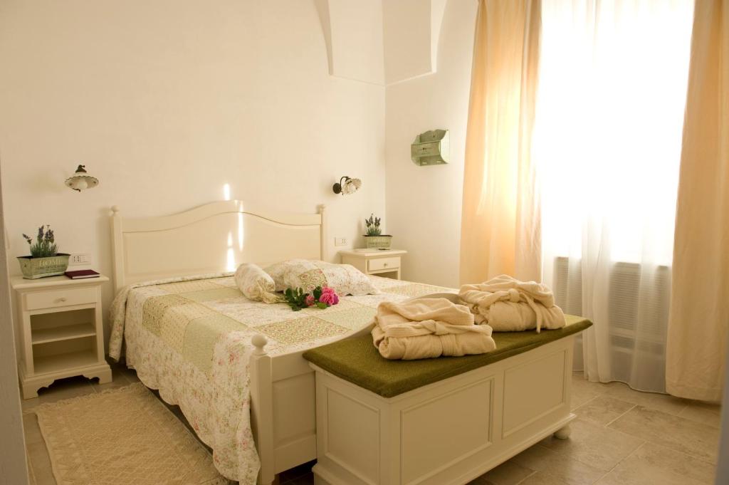 een slaapkamer met een bed met twee handdoeken erop bij Masseria Bianca di Puglia in Monopoli