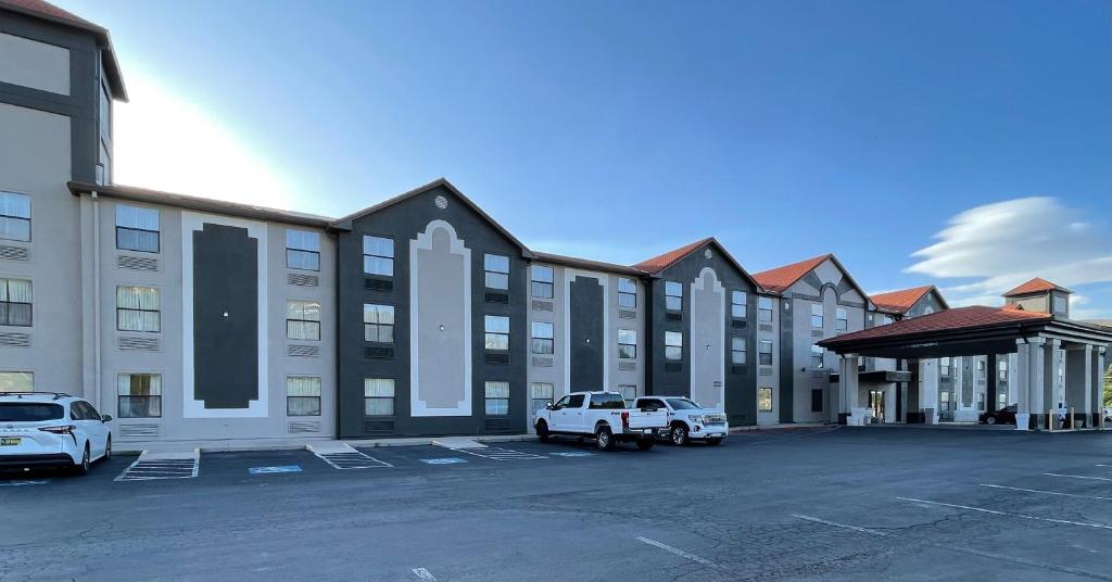 un grand bâtiment avec des voitures garées dans un parking dans l'établissement Ruidoso Mountain Inn, à Ruidoso