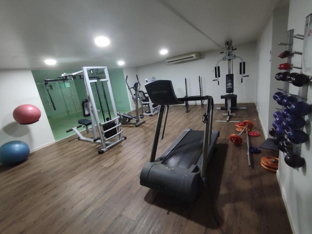 um ginásio com passadeiras e equipamento de exercício numa sala em Bluesunset em João Pessoa