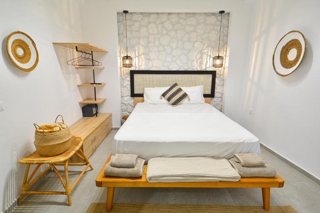 a bedroom with a bed and a bench with towels at Oikia Suites Mykonos in Mýkonos City