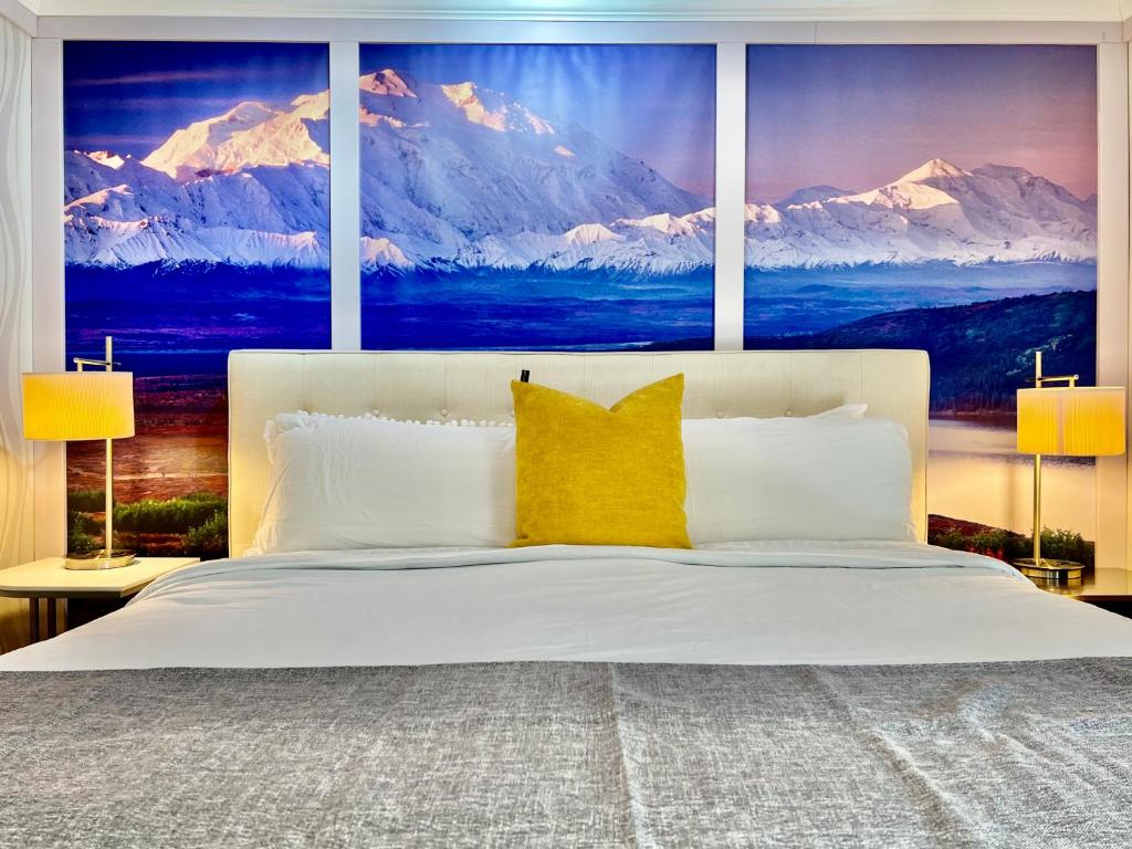 a bedroom with a large bed with snow covered mountains at Sunshine Cottage in Talkeetna