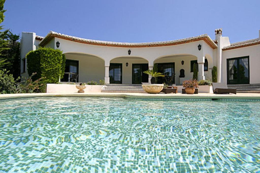a large swimming pool in front of a house at La Cumbre in Jávea