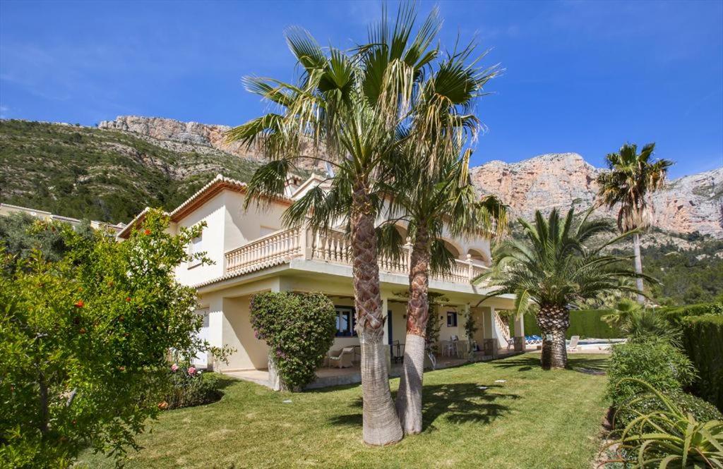 a house with palm trees in front of a mountain at El Hayuco 10 in Jávea