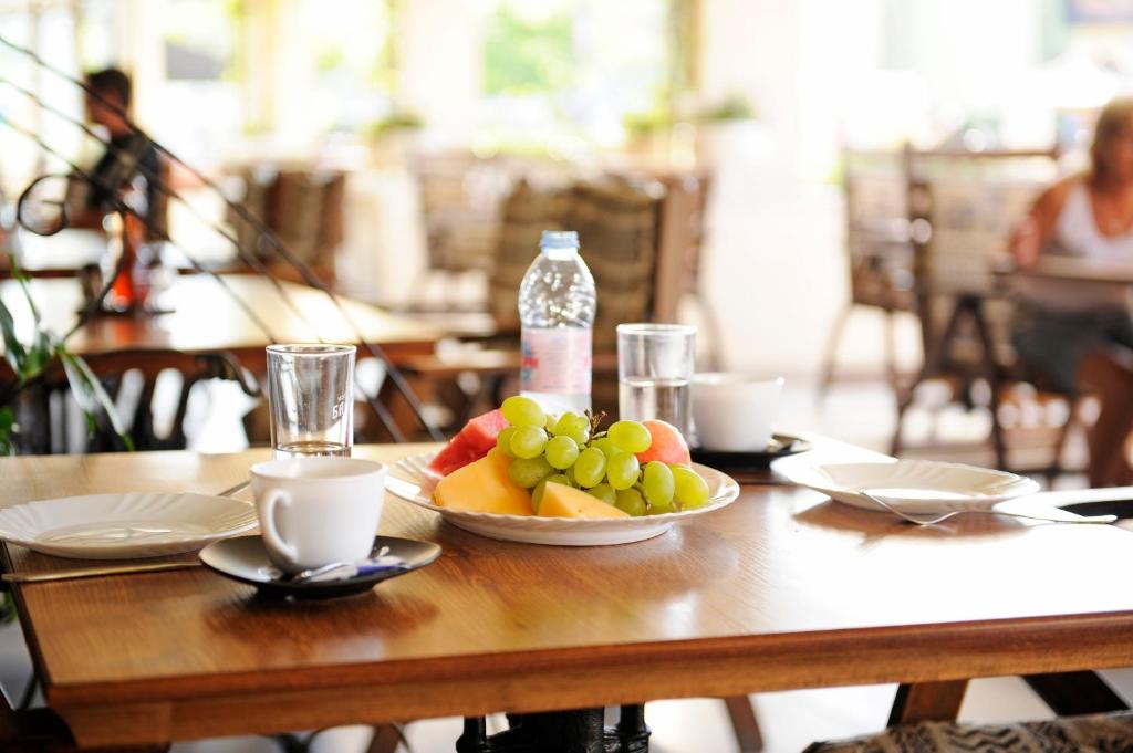 a wooden table with a bowl of fruit on it at Lotus Family Hotel - Free Parking in Sunny Beach
