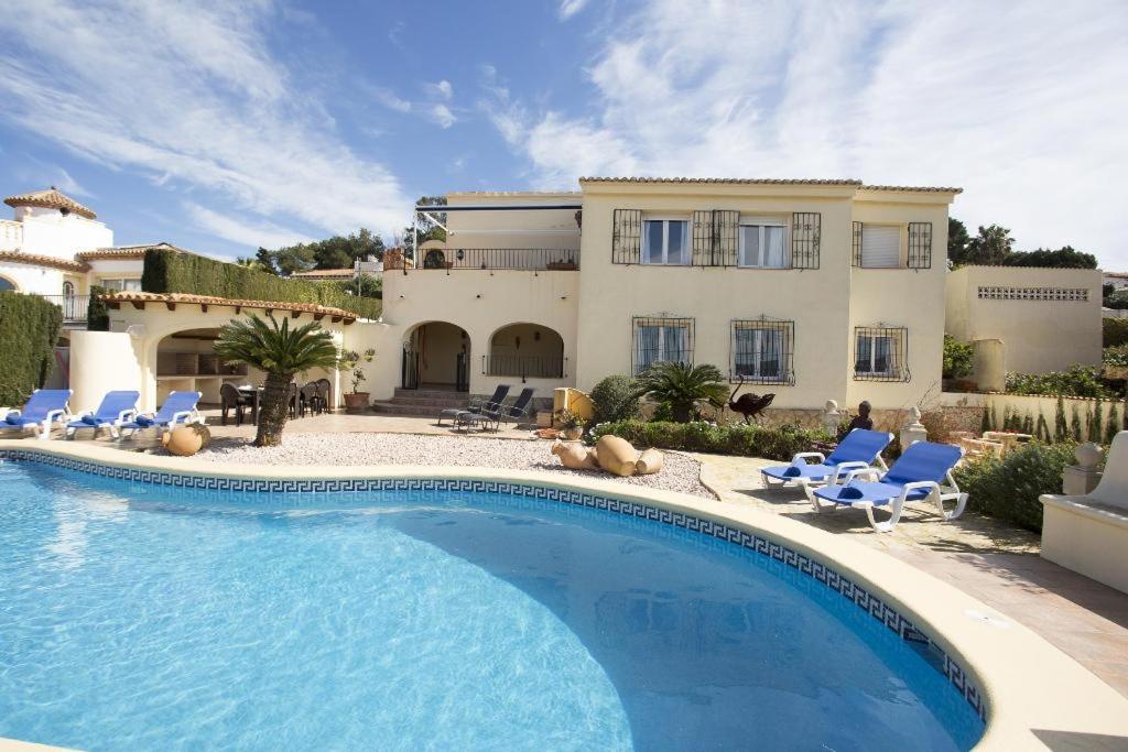 a villa with a swimming pool in front of a house at Casa Stella in Jávea