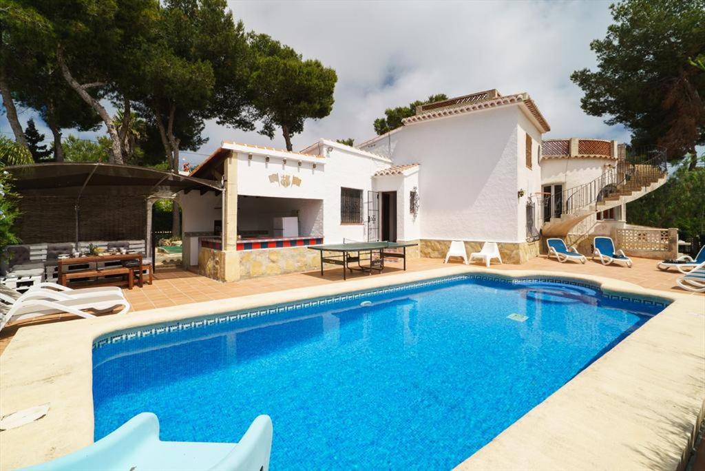 Villa con piscina frente a una casa en Escabusso, en Jávea