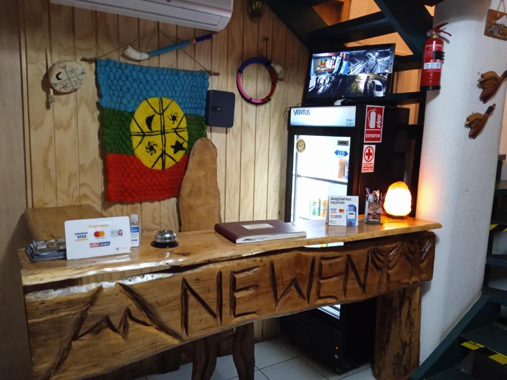 Pokój z drewnianym stołem i lodówką w obiekcie Hostal Newen w mieście Villarrica