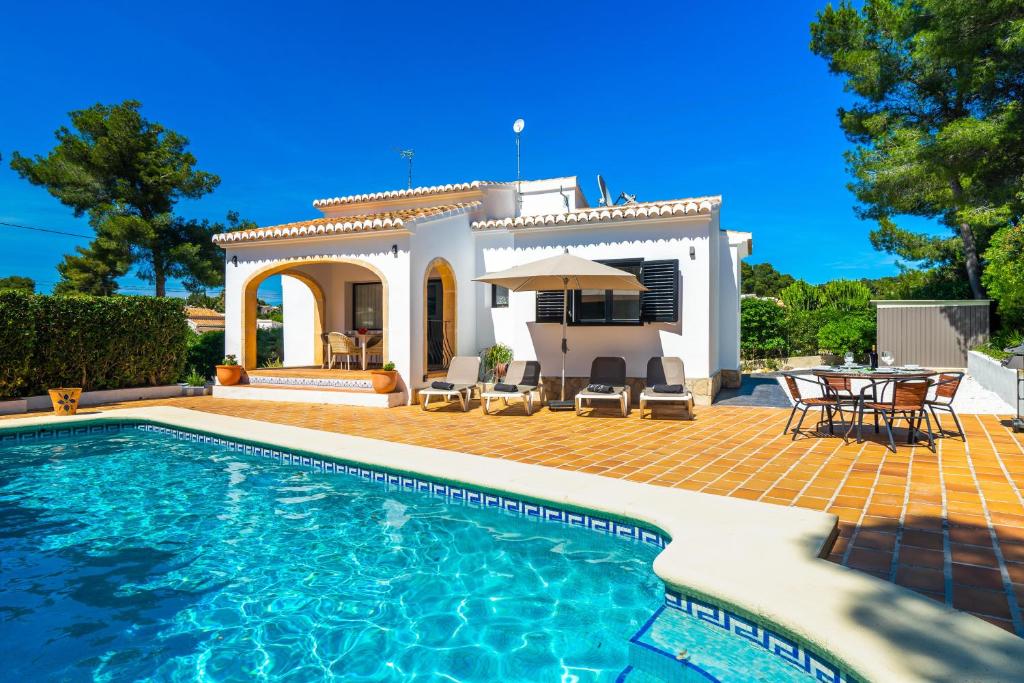 une villa avec une piscine en face d'une maison dans l'établissement Cornelia, à Jávea