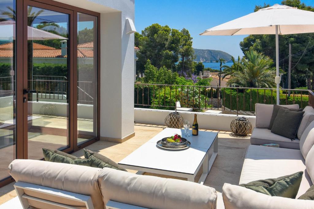a patio with a couch and an umbrella at Amipa by Aguilarent in Moraira