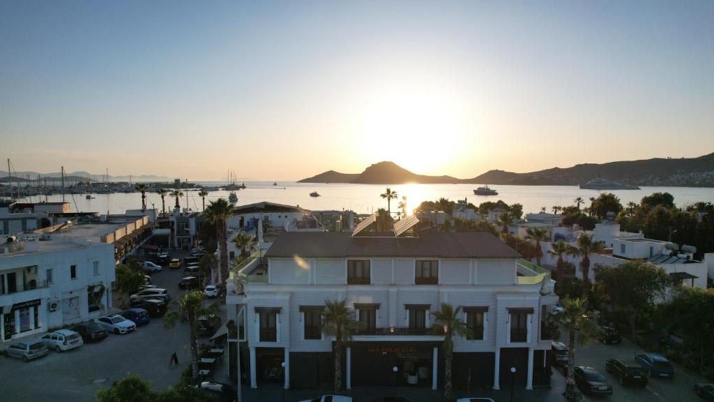 an aerial view of a city with the sun setting at Sea Palm Otel Yalıkavak in Yalıkavak